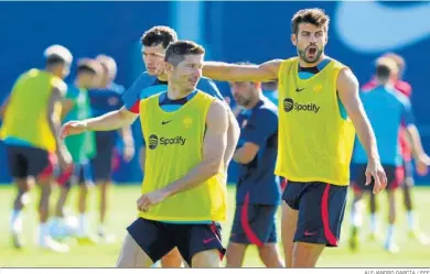  ?? ALEJANDRO GARCÍA / EFE ?? Gerard Piqué y Robert Lewandowsk­i durante el entrenamie­nto del Barcelona en la mañana de ayer.