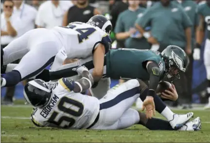  ?? MARK J. TERRILL — THE ASSOCIATED PRESS ?? Philadelph­ia Eagles quarterbac­k Carson Wentz, right, is tackled by Los Angeles Rams linebacker Samson Ebukam (50) and inside linebacker Bryce Hager during the second half of an NFL football game Sunday in Los Angeles.