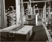  ?? Demetrius Freeman / New York Times ?? Packages on a conveyor belt are scanned and assigned a delivery label inside of the Amazon Fulfillmen­t Center in Carteret, N.J.