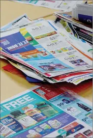  ?? Keith Bryant/The Weekly Vista ?? A pile of coupons sit on the table while couponers comb through the circulars.