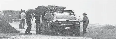  ?? AP ?? Law enforcemen­t officers gather near the scene where the body of a woman was found near Interstate 35 north of Laredo, Texas, on Saturday.