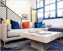  ?? TEXT BY SHANNON DOMINY. PICTURE BY REYNOLDS ROGERS. ?? A concrete coffee table from CB2 sits at the center of Poul Olson’s living room, tying into the space’s grayscale color palette and adding an industrial touch.