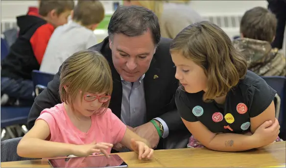  ?? SCOTT ANDERSON/SOUTHWEST BOOSTER ?? Deputy Premier and Minister of Education Gordon Wyant explored the Askî’s Pond ipad app with O.M. Irwin Grade 1 students Emmersyn Wolfe and Carrington Kupczynski on October 18.