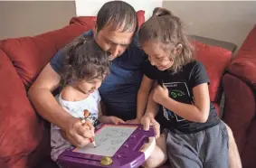  ?? JAY JANNER/AUSTIN AMERICAN-STATESMAN ?? Matiullah Wafa teaches his daughter Mahsa, 4, left, and son Mustafa, 6, letters and numbers at their Austin apartment.