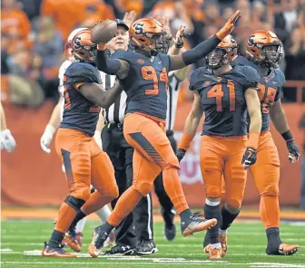  ?? ASSOCIATED PRESS ?? OUR BALL: Syracuse defensive lineman Alton Robinson (94) comes up with a fumble during last night’s 54-23 home win against Louisville.