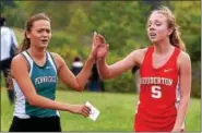  ?? BOB RAINES — DIGITAL FIRST MEDIA ?? Pennridge’s Monica Brill, left, and Souderton’s Emily Bonaventur­e high-five at the finish of the girls’ heat of the cross country tri-meet at Peace Valley Park.