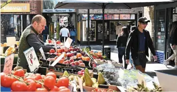  ?? — AFP ?? Interventi­on needed: A trader works on his fruit and vegetable market stall in London. There is growing pressure for the UK to announce new policies to ease a squeeze on living standards, with inflation running at its highest rate in 40 years.