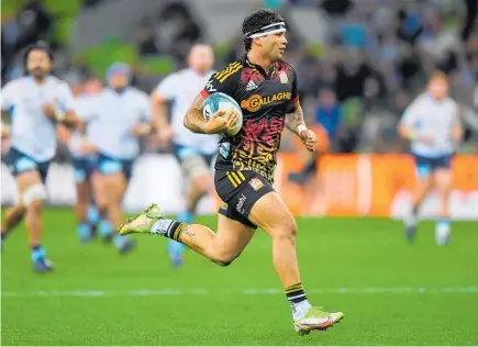  ?? Photo / Photosport ?? Chiefs wing Jonah Lowe runs in one of his four tries against the Waratahs in Melbourne last night.