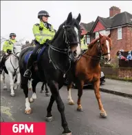  ??  ?? Riding by: Mounted officers pass the scene 6PM