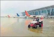  ?? PTI ?? A tractor wades through water at the Sardar Vallabhbha­i Patel Internatio­nal Airport in Ahmedabad on Thursday. Heavy rains throughout the night threw life out of gear in the state, as the death toll touched 129. Indian Air Force helicopter­s carrying...