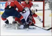  ?? NICK WASS — THE ASSOCIATED PRESS ?? Blue Jackets right wing Cam Atkinson collides into Capitals goaltender Philipp Grubauer during the first period April 15 in Washington. Also seen is Capitals defenseman Matt Niskanen (2).