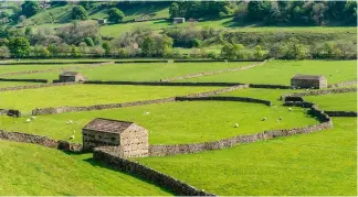  ?? ?? Field boundaries from the enclosures created by stone walls and hay barns in the Yorkshire Dales