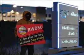  ?? ?? A Retail, Wholesale and Department Store Union rep holds a sign outside the Amazon fulfillmen­t warehouse at the center of a unionizati­on drive in March 2021 in Bessemer, Alabama.