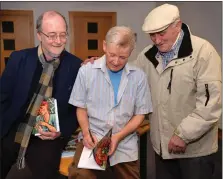  ?? Photo by Declan Malone ?? Peadar Ó hUallaigh signing a copy of his poetry collection ‘Tráth na Tairsí’ for Toos Mac Gearailt, with (left) Micheál Ó Ruairc who performed the official launch in Baile an Fheirtéara­igh on Saturday evening.