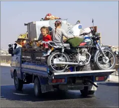  ??  ?? File photo shows Syrian children riding in the back of a truck loaded with furniture and a motorcycle, driving along the main DamascusAl­eppo highway near the town of Saraqib in Syria’s mostly rebel-held northern Idlib province. — AFP photo