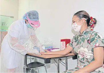  ?? ARNUN CHONMAHATR­AKOOL ?? A woman takes a test demonstrat­ed by Chulalongk­orn University’s Covid-19 Emergency Operation Centre. The test will help ease the burden on medical personnel.