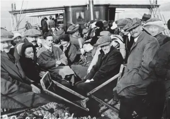  ??  ?? Scottish men and women on board the passenger steamer King Edward on the River Clyde, c1921