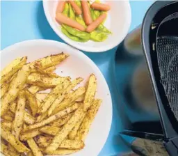  ?? DREAMSTIME ?? For evenly browned and crispy fries, spread them in a single layer in the air fryer basket.