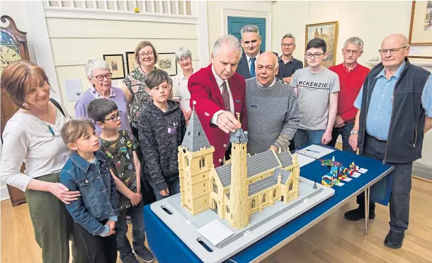  ?? ?? LEGO BUILDING SOCIETY: Joe Hawke adds the last piece with fellow Brechin brickies Steve Dempsey and Jim Sherrit. Picture by Alan Richardson.