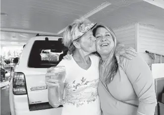 ??  ?? Venture Out RV Resort resident Paulette Brake kisses resident and Waterfront Keys Realty broker Trish Brummer last week, happy that a year after Irma, their community is cleaned up .