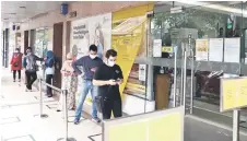  ?? — Bernama photo ?? Customers are seen queuing up in front of a local bank. The three-month interest waiver proposed by the MOF recently for loan moratorium recipients under the Pemulih relief programme will impinge on banks’ earnings recovery this year, RAM Ratings opines.