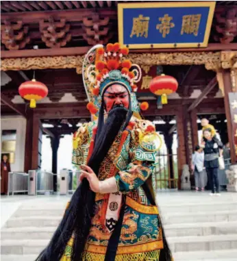  ??  ?? В г. Юньчэн перед храмом Гуань-ди китайский актер показывает, какой образ Гуань-ди сложился в традиции пекинской оперы (фото Цинь Биня)