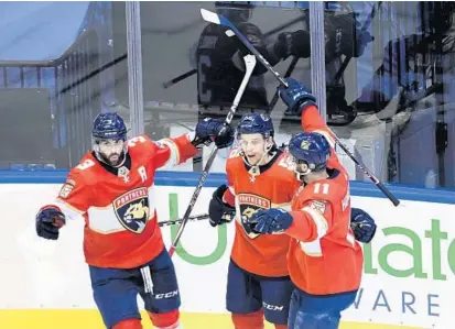  ?? NATHAN DENETTE/AP ?? Panthers left wing Erik Haula (56) celebrates his goal with teammates Keith Yandle (3) and Jonathan Huberdeau after scoring against the Islanders on Wednesday during Game 3 of the teams’ Stanley Cup playoff series.