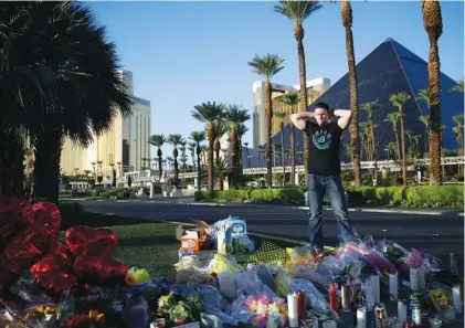  ?? ASSOCIATED PRESS PHOTOS ?? Brandon Metzger, of Temecula, Calif., pauses Wednesday at a memorial for the victims of the mass shooting in Las Vegas, Nev.