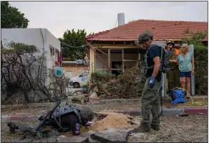  ?? (AP/Ohad Zwigenberg) ?? Members of an Israeli bomb squad unit inspect a site hit by a rocket fired from the Gaza Strip in Ashkelon, Israel, on Monday.