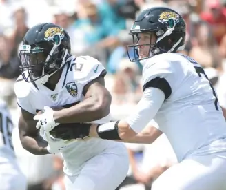  ?? PHELAN M. EBENHACK/AP ?? Bucs running back Leonard Fournette (left) doesn’t seem to regard former Jaguars teammate Nick Foles — now with the Bears — as a real quarterbac­k, based on a remark he made Tuesday.