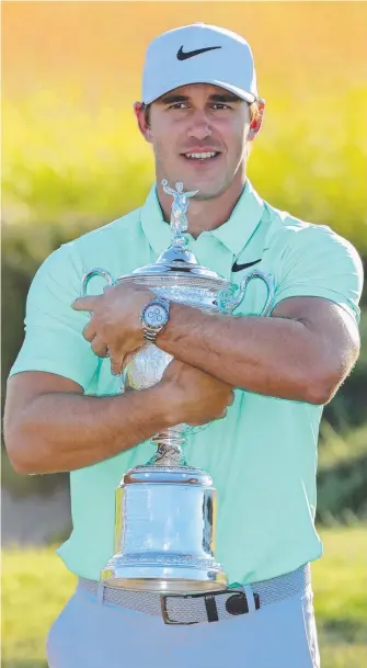  ?? Picture: GETTY IMAGES ?? Brooks Koepka takes a firm grip on his first major trophy at Erin Hills.