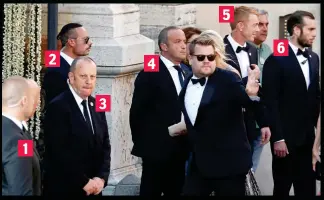  ??  ?? No time to chat: Corden waves as he walks past six security guards