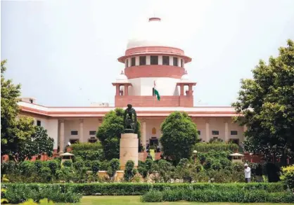  ?? File photo/associated Press ?? A gardener works in the lawn of the Supreme Court in New Delhi, India, on Aug.22, 2017.