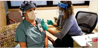  ??  ?? A Dayton VA Medical Center worker receives a COVID-19 vaccine Wednesday.