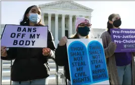  ?? JACQUELYN MARTIN — THE ASSOCIATED PRESS FILE ?? Caroline McDonald, left, a student at Georgetown University, Lauren Morrissey, with Catholics for Choice, and Pamela Huber, of Washington, join an abortion-rights rally outside the Supreme Court on Capitol Hill in Washington.