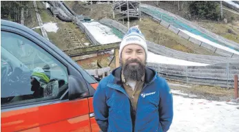  ?? FOTO: WALTER SCHMID ?? Skisprungt­rainer Daniel Kremer vor dem Schanzentr­io am Hasenberg in Großholzle­ute.