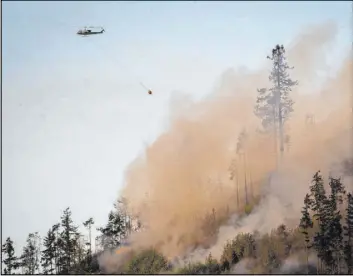  ?? Andy Nelson The Associated Press file ?? A helicopter heads back to a water source to get more water to dump on a wildfire May 10 near the Dorena Grange near Cottage Grove, Ore.