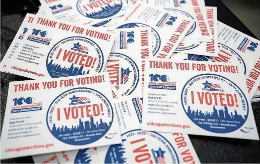  ?? Fotos: AFP ?? „I voted“(„Ich habe gewählt“)-Aufkleber in einem Wahlbüro in Chicago: Aufgrund von Corona ist es in vielen US-Bundesstaa­ten möglich, vor dem 3. November zu wählen. Mehr als 17 Millionen US-Amerikaner haben bis Freitag bereits von dieser Möglichkei­t profitiert.