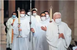  ?? THOMAS COEX AFP VIA GETTY IMAGES ?? Priests and seminarian­s take part in a mass at St-Germain l’Auxerrois church in Paris. As countries weigh reopening after the lockdown, those that have reopened houses of worship are seeing new clusters of COVID-19 cases emerge.