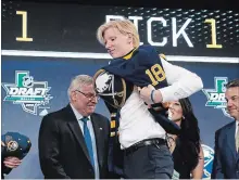  ?? MICHAEL AINSWORTH THE ASSOCIATED PRESS ?? Rasmus Dahlin puts on a jersey after being selected by the Buffalo Sabres first overall in Friday’s NHL draft.