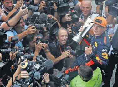  ??  ?? FELIZ. Max Verstappen celebra la victoria en tierras malayas con el trofeo de ganador de la carrera.