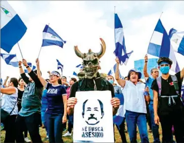  ?? DIANA ULLOA/AFP ?? A student holds a sign depicting Nicaraguan President Daniel Ortega that reads ‘Assassin Wanted’ during a protest in Managua on Tuesday.