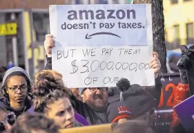  ?? BEBETO MATTHEWS/ASSOCIATED PRESS ?? A protester holds up an anti-Amazon sign during a rally last Novemberop­posing Amazon getting subsidies to locate in Long Island City, New York.