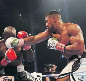  ?? FOTO: GETTY ?? Joshua conecta un golpe contra el rostro de Takam en la pelea por el título mundial