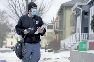  ?? Robert F. Bukaty, The Associated Press ?? Postal carrier Josiah Morse makes his rounds Wednesday in Portland, Maine.