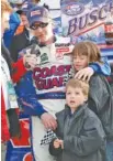  ?? AP PHOTO/GENE BLYTHE ?? Jeff Burton puts his arm around his children Paige, 10, and Harrison, 5, as he is interviewe­d in victory lane after winning the March 2006 race at Atlanta Motor Speedway.