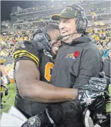 ?? CANADIAN PRESS FILE PHOTO ?? Kent Austin gets a hug from Hamilton Tiger-Cats defensive tackle Ted Laurent after the team’s win in the 2014 East Division final. The Ticats went to the Grey Cup twice in Austin’s tenure.