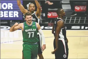  ?? The Associated Press ?? CELEBRATIO­N: Dallas Mavericks guard Luka Doncic, bottom left, reacts after drawing a foul during the first half of Sunday’s game against the Los Angeles Clippers in Los Angeles.