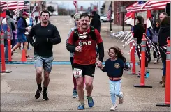  ?? File photo by Hunt Mercier ?? ■ Canely Newberry joins her father, Joseph, as he runs toward the finish line at 2019’s 12th annual Run the Line Half-Marathon in Texarkana. The 2021 race has been canceled because of the COVID-19 pandemic.