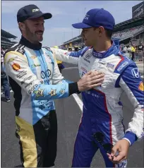  ?? DARRON CUMMINGS — THE ASSOCIATED PRESS ?? Agustin Canapino, left, talks with Alex Palou before practice for the Indianapol­is 500 at Indianapol­is Motor Speedway on Monday. Palou will be the polesitter this year’s Indy 500on Sunday.